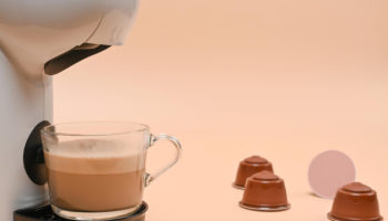 close-up-view-coffee-machine-cup-beige-background